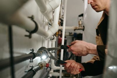 Technician inspecting commercial plumbing pipes in Sunnyvale